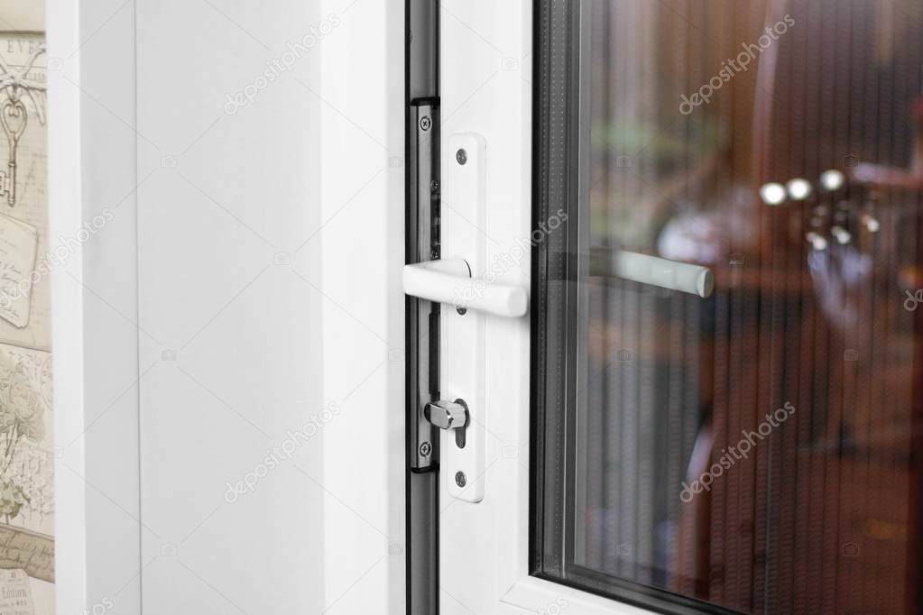 A man's hand opens a white plastic door. Close up