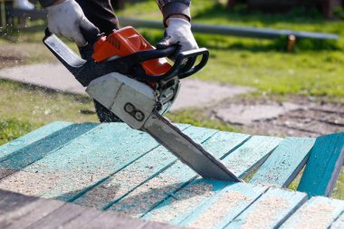 Elektrikli testereyle tahtaları testereyle gören adam. Yakın çekim