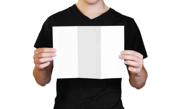 Un hombre sosteniendo una hoja blanca de papel. Llevando un folleto. Cerrar u — Foto de Stock