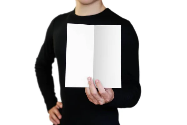 Un hombre sosteniendo una hoja blanca de papel. Llevando un folleto. Cerrar u —  Fotos de Stock