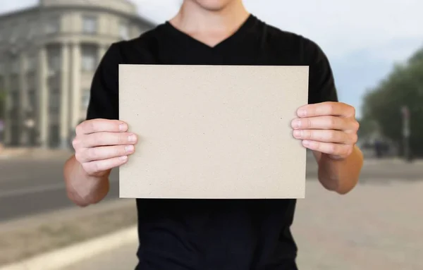 Egy ember, kezében egy darab kartonpapír. Egy bookl birtoklása — Stock Fotó