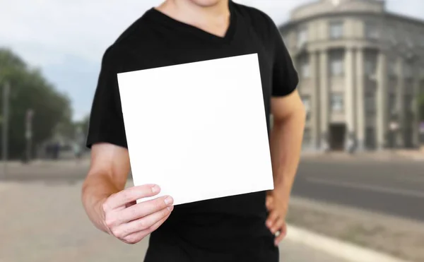 Egy férfi, aki egy fehér papírlapot. Könyvecske tartása. U bezár — Stock Fotó