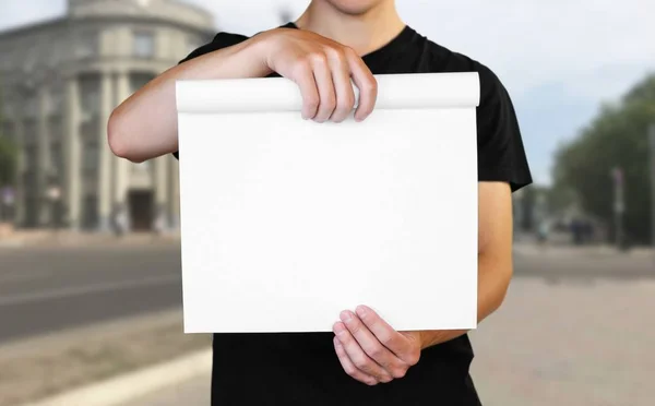 Ein Mann hält ein weißes Blatt Papier. In der Hand ein Büchlein. schließen u — Stockfoto