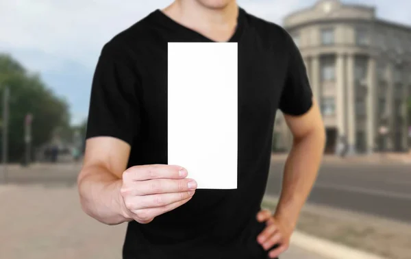 Muž, který drží bílý list papíru. Držím brožuru. Zavřít u — Stock fotografie