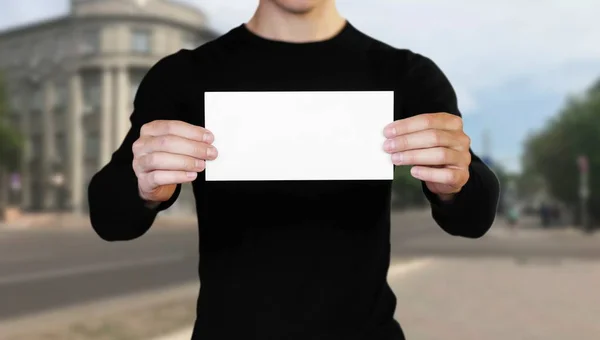 Een man met een wit vel papier. Het houden van een boekje. Sluit u — Stockfoto