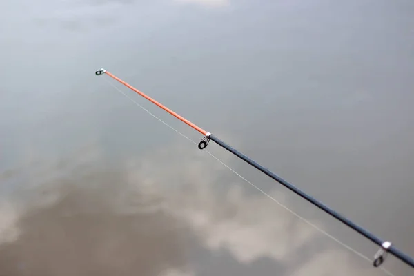 Canna da pesca sullo sfondo del fiume. Da vicino. — Foto Stock
