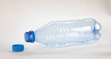 İçme suyu olan mavi bir şişe. Kapatın. Beyaz torba üzerinde izole edilmiş