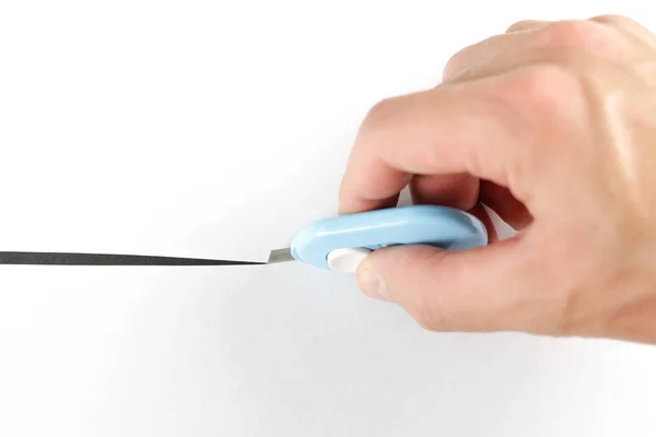 Hand holds a small stationery knife and cuts paper. Close up — ストック写真