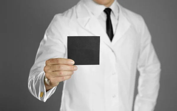 Doktorze. Mężczyzna w białym płaszczu, białej koszuli i czarnym krawacie trzyma — Zdjęcie stockowe