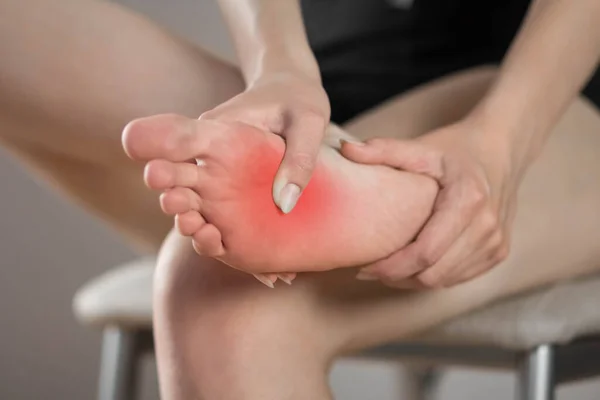 Schmerzen Fuß Einer Frau Rot Hervorgehoben Auf Grauem Grund Nahaufnahme — Stockfoto