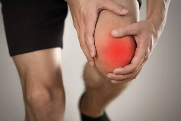 Dolor Rodilla Hombre Destacado Rojo Sobre Fondo Gris Cerca —  Fotos de Stock