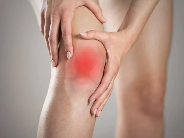 Pain Knee Woman Highlighted Red Gray Background Close — Stock Photo, Image