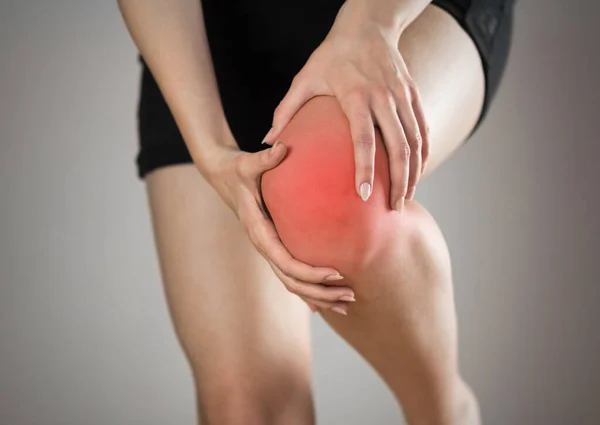 Pain Knee Woman Highlighted Red Gray Background Close — Stock Photo, Image