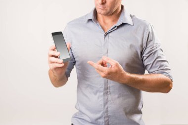 Telefon tutan ve diğer eliyle ekrana işaret eden adam.