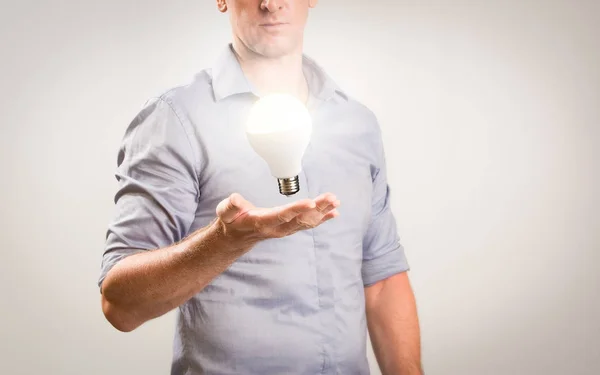 Hombre de negocios vestido casual con bombilla flotante que brilla sobre su mano. Idea de negocio imagen conceptual con espacio de copia para texto . —  Fotos de Stock