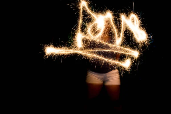 Unknown young woman playing with sparklers - shot with slow shut — Stock Photo, Image
