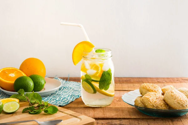 Summer theme with orange and lime infused soda water drink on wooden tabletop