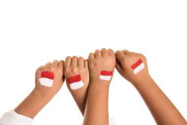 Childrens hands making fist with red and white Indonesian flag painted  clipart
