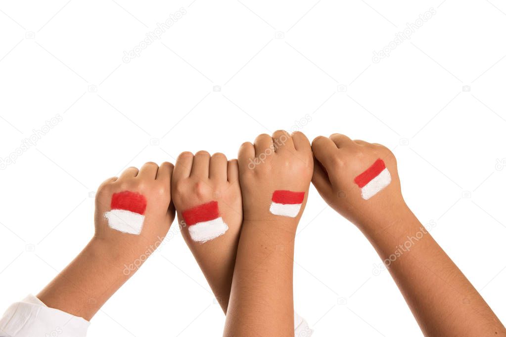 Childrens hands making fist with red and white Indonesian flag painted