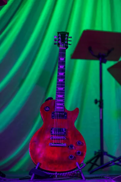 Beautiful electric guitar on stage. Green background.