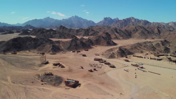 撒哈拉沙漠 沙漠山脉的俯瞰 木制贝都因人住房 游客们在村里走来走去 — 图库视频影像