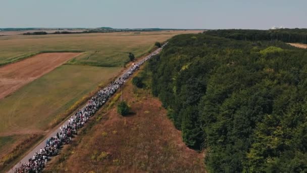 Les chrétiens orthodoxes font une procession religieuse. Vue de dessus de la procession, route, champs verts et jaunes, forêt .