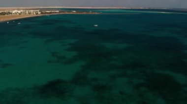 Hurghada bölgesindeki Kızıldeniz üzerinde güzel bir kuadkopter uçuşu. Temiz yeşil su. Beyaz kayıklar denizde yüzer.