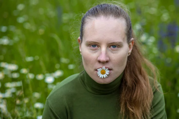 Egy Kék Szemű Portréja Fehér Kamillával Szájában Egy Zöld Pulóverben — Stock Fotó