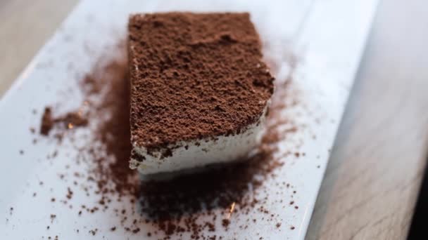 ビデオでは 美味しいチョコレートのパン粉のトッピングで飾られたおいしいケーキが展示されています チョコレートパン粉は この口水処理の感覚的な経験を強化する楽しいクランチを追加します — ストック動画