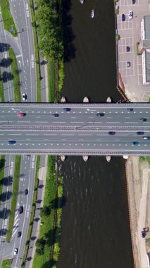 Utrecht, Utrecht bölgesi, Hollanda - 09.06.2025: Nehir, sanayi binaları, tekneler ve yerleşim alanları ile modern bir şehir manzarası. Köprüsü olan işlek bir yol denizi geçer.