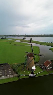 Yat ve rıhtımlarla dolu, yeşil çimenlikler ve şık deniz manzaralı evlerle çevrili modern bir marinadan bir tekne geçiyor. Dar kanalların yemyeşil alanlar boyunca uzanan havadan görünüşü