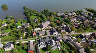 Melez tarzı evleri olan göl kenti, merkezi bir kilise ya da kamu binası, yeşil alanlar ve özel rıhtım manzarası. Düzenli yerleşim planlama ile deniz kenarı erişimini harmanlıyor..