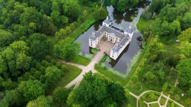 Dikdörtgen şeklinde bir hava manzarası, hendek ve sık orman ile çevrili dört kule kalesi, manikürlü bahçeler ve bereketli manzaralı ağaç çizgili yollarla bir köprü ile bağlı.