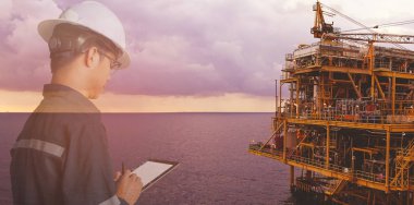 Petrol ve gaz iş kavramı için offshore petrol ve gaz platform arka plan ile tablet kullanarak platform veya bitki mühendis veya teknisyen adamın güvenlik kask ile çift pozlama işletilen.