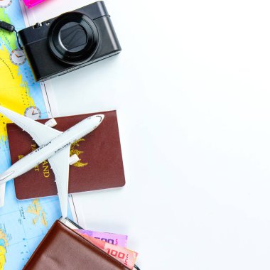 Yaz tatili için seyahat aksesuarı kostümü konsepti. Pasaportlar, bavullar, harita, akıllı telefon, güneş gözlükleri, kamera, not defteri, beyaz kot pantolon.