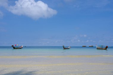 Bulutlu bir günde gün batımında Koh Tao 'da tekne ve plaj.