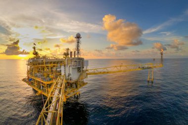 Akşamları petrol ve doğalgaz konsepti için güzel gökyüzü olan açık deniz petrol ve gaz platformu.
