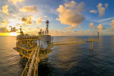 Akşamları petrol ve doğalgaz konsepti için güzel gökyüzü olan açık deniz petrol ve gaz platformu.