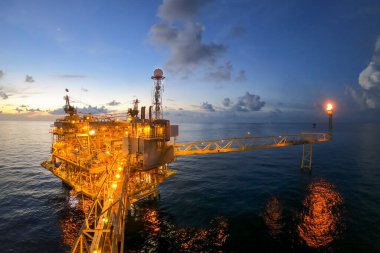 Akşamları petrol ve doğalgaz konsepti için güzel gökyüzü olan açık deniz petrol ve gaz platformu.