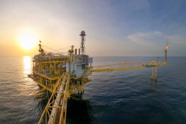 Akşamları petrol ve doğalgaz konsepti için güzel gökyüzü olan açık deniz petrol ve gaz platformu.