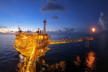 Akşamları petrol ve doğalgaz konsepti için güzel gökyüzü olan açık deniz petrol ve gaz platformu.