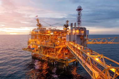 İş dünyası konsepti için gün batımında güzel gökyüzü olan açık deniz petrol platformu..