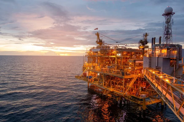İş dünyası konsepti için gün batımında güzel gökyüzü olan açık deniz petrol platformu..