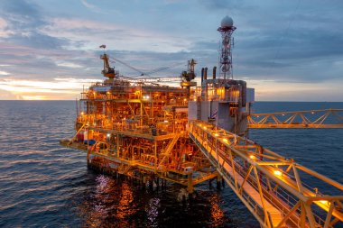 İş dünyası konsepti için gün batımında güzel gökyüzü olan açık deniz petrol platformu..