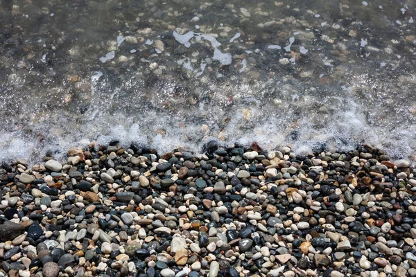 鹅卵石海滩 天然湿卵石和海水背景 — 图库照片