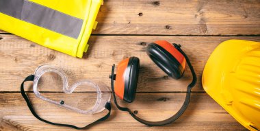 İnşaat site emanet. Koruyucu baret, kulaklık ve ahşap arka plan, kopya alanı, gözlük görünümü top