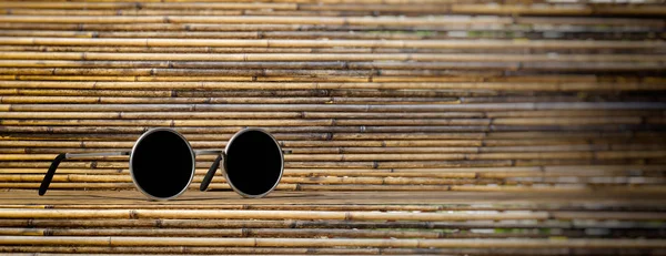 Letní Koncept Sluneční Brýle Stříbrné Kulaté Černé Plexisklo Bambusové Pozadí — Stock fotografie