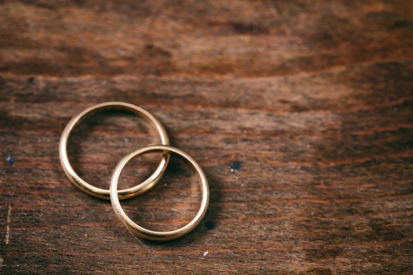 一对金色的结婚戒指在木质背景 复制空间 顶部视图 — 图库照片