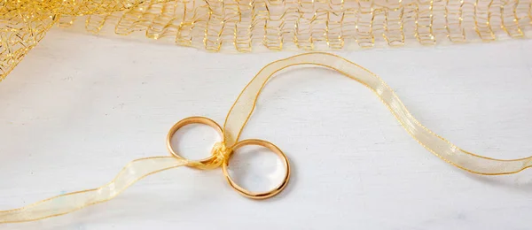 Pair Golden Wedding Rings Tied Golden Ribbon White Wooden Background — Stock Photo, Image