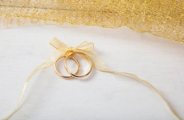 Pair Golden Wedding Rings Tied Golden Ribbon White Wooden Background — Stock Photo, Image